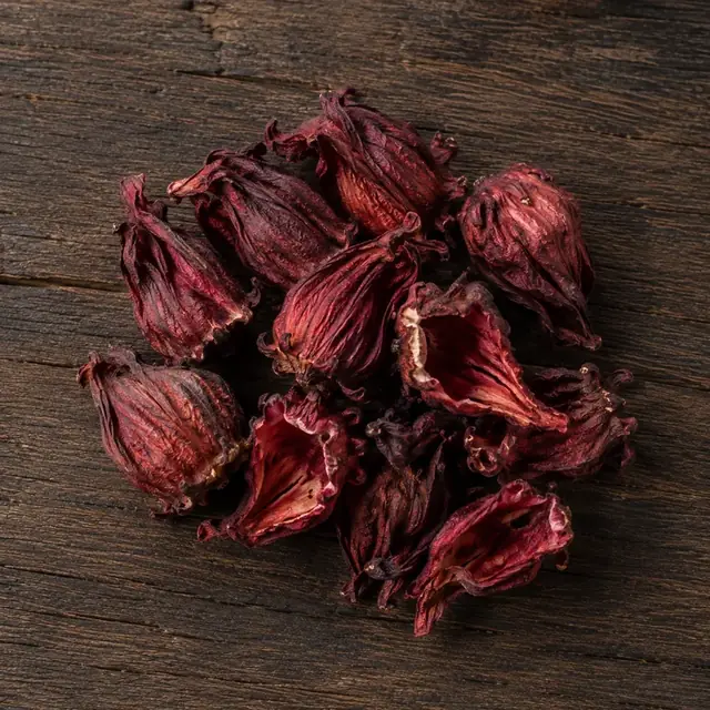 Bunga roselle kering berwarna merah di atas permukaan kayu